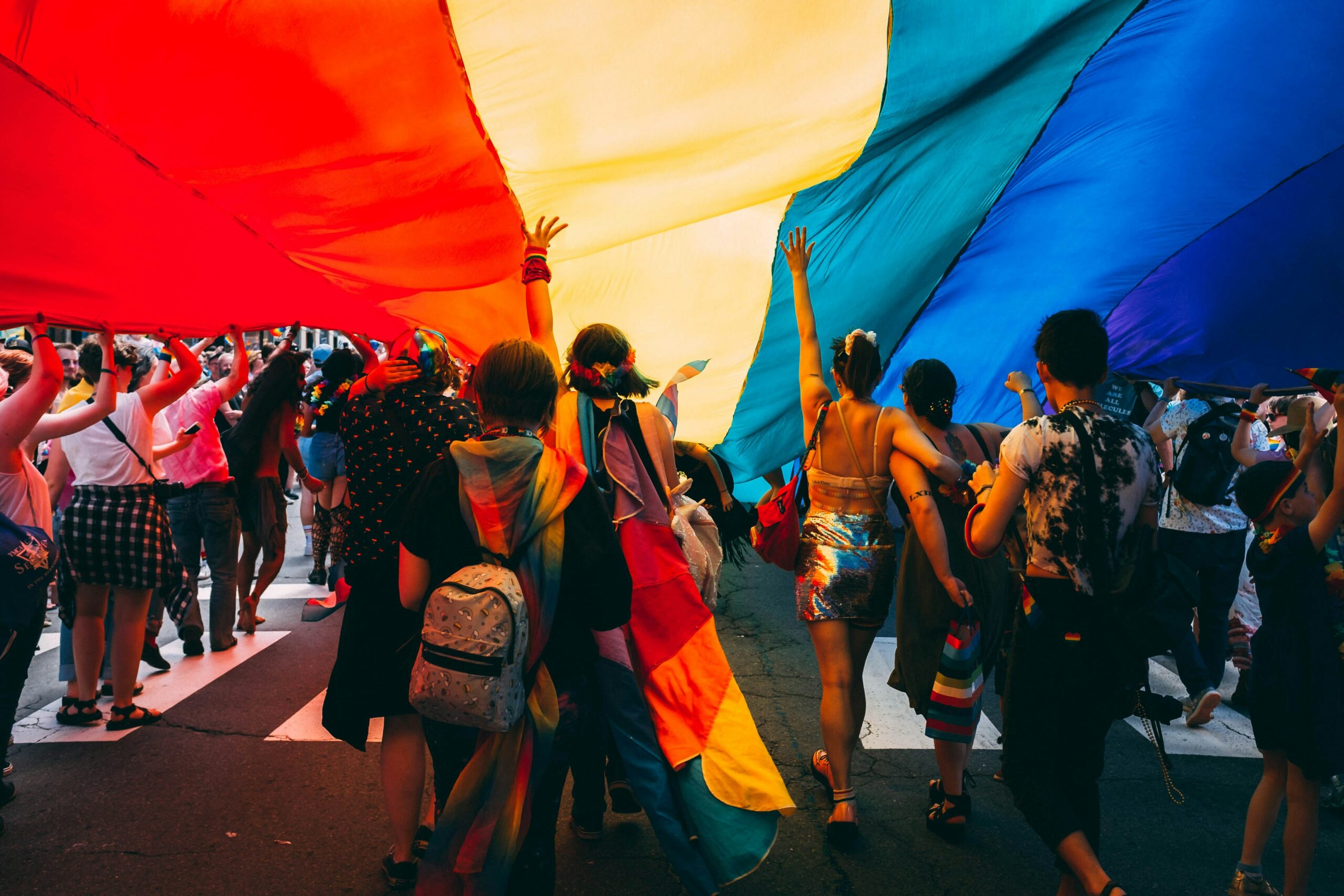 People marching under a pride flag.