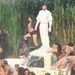 Bad Bunny at Super Bowl Half Time Show standing on top of a white pick up truck surrounded by dancers