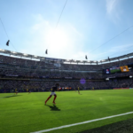 Wide view of a FIFA World Cup match in a packed stadium, with players competing on the field before thousands of supporters.