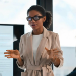 Business leader wearing AI smart glasses presenting during a workplace meeting discussing technology and collaboration