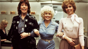 Three women standing together in an office scene from the 1980 film 9 to 5