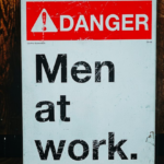 Men at work warning sign representing conversations about masculinity, antifeminism and workplace culture